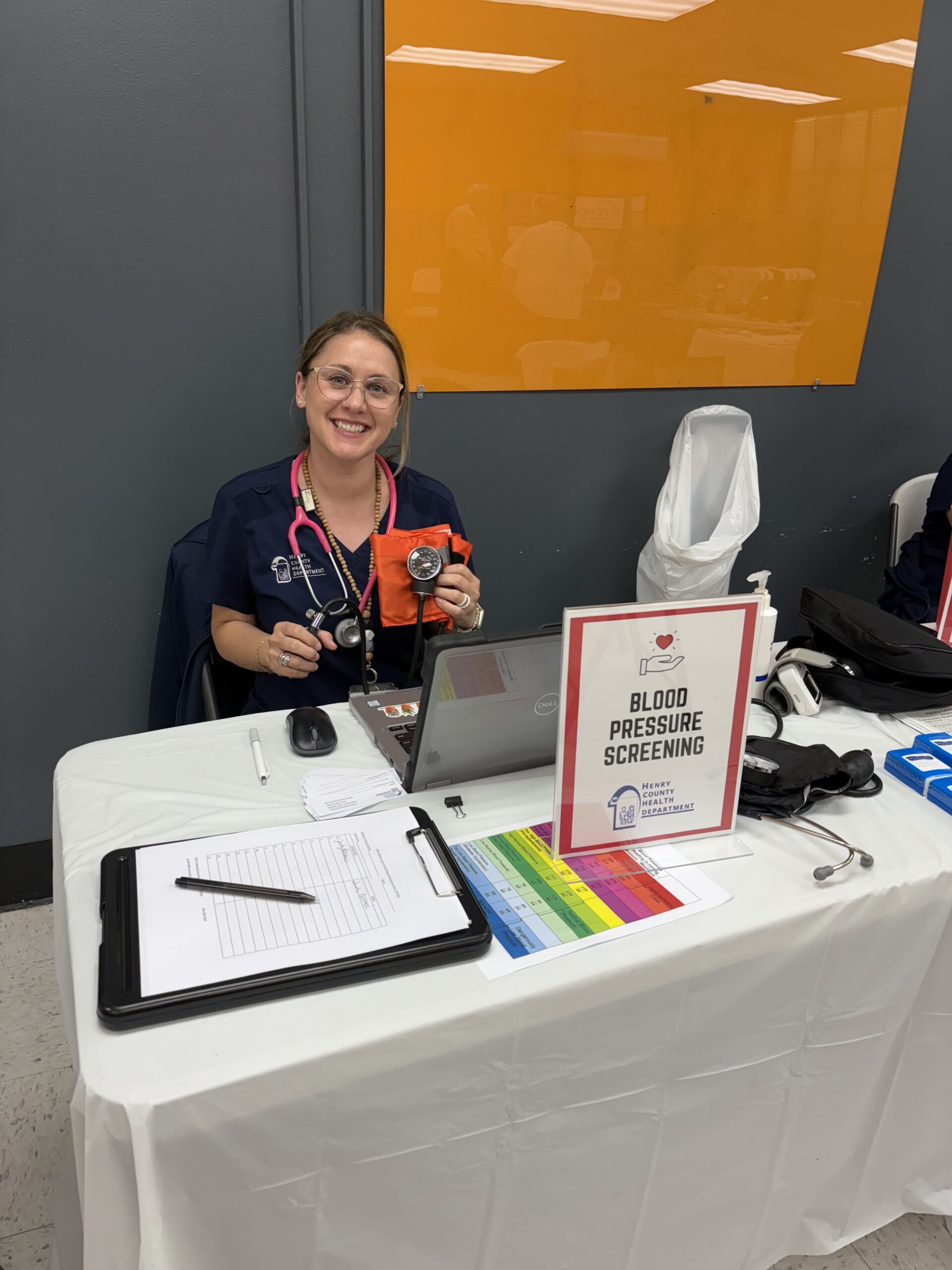 Kind nurse providing blood pressure checks at local business